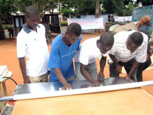 Operation Amis du Soleil participants start the solar cooker construction process by adhering reflective foil to cardboard