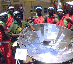 SCI's Faustine Odaba explains solar cooking to a group of dancers.
